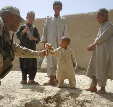 Soldier gives an Afghan child his first stuffed animal.