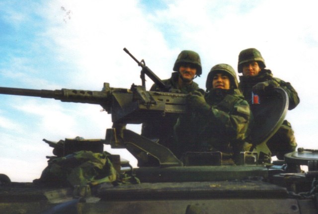Photo: three soldiers on top of a mechanized mortar vehicles.